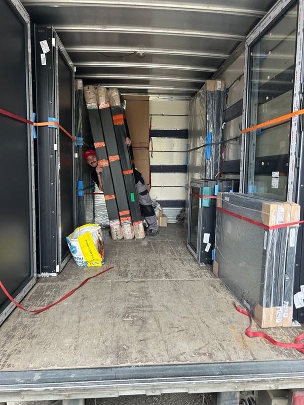 Intérieur d’un camion chargé de fenêtres et de portes sanglées